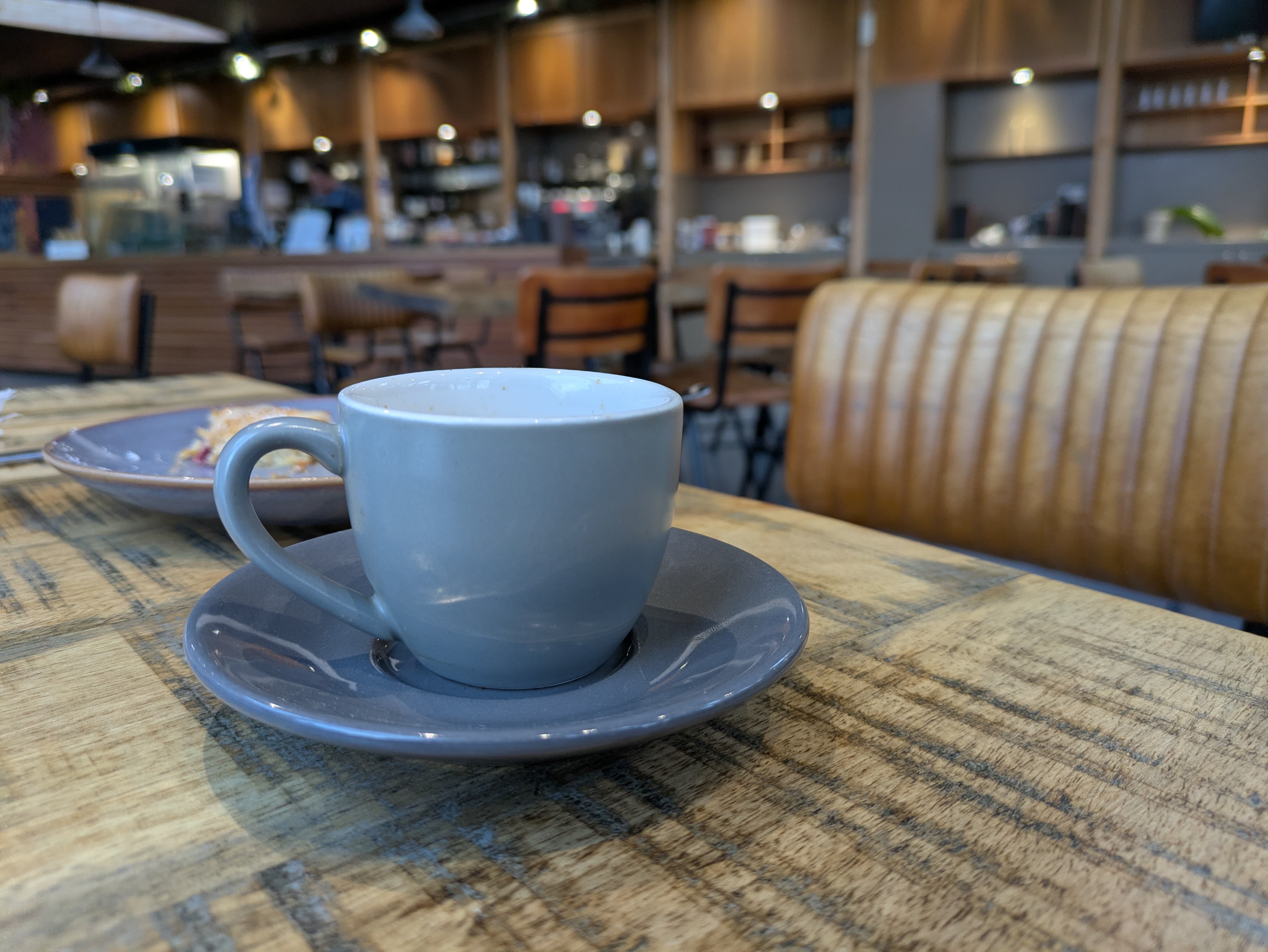 An espresso cup sitting on a wooden table