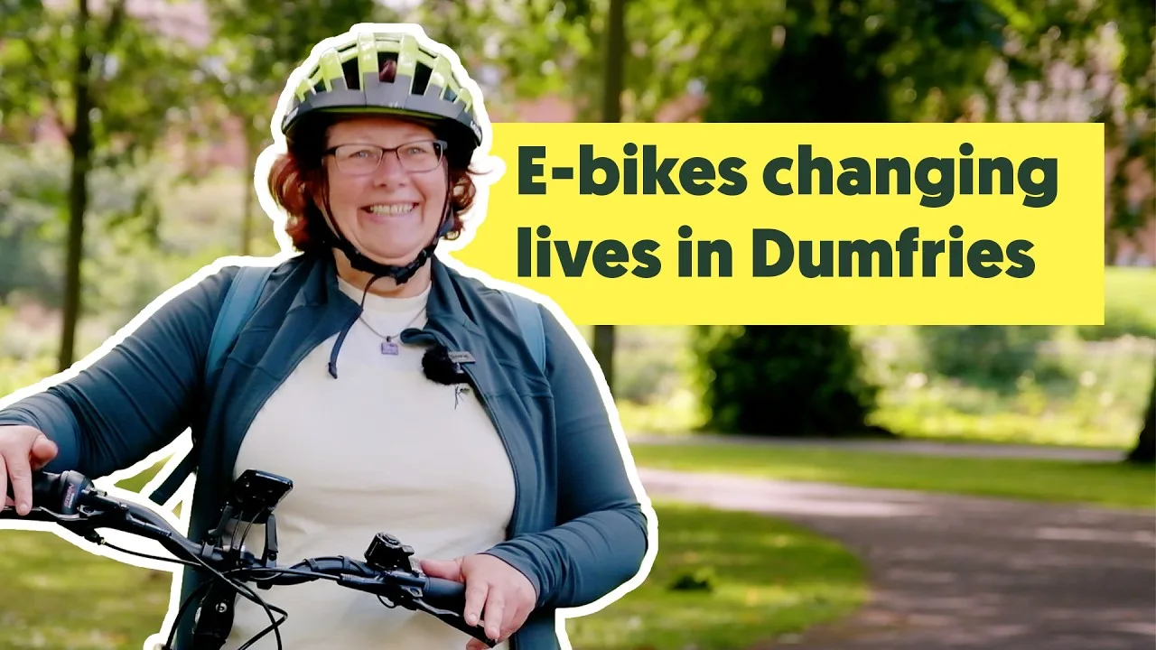 E-bikes changing lives in Dumfries A woman in a cycle helmet standing with an e-bike on a tree-lined path in Dumfries